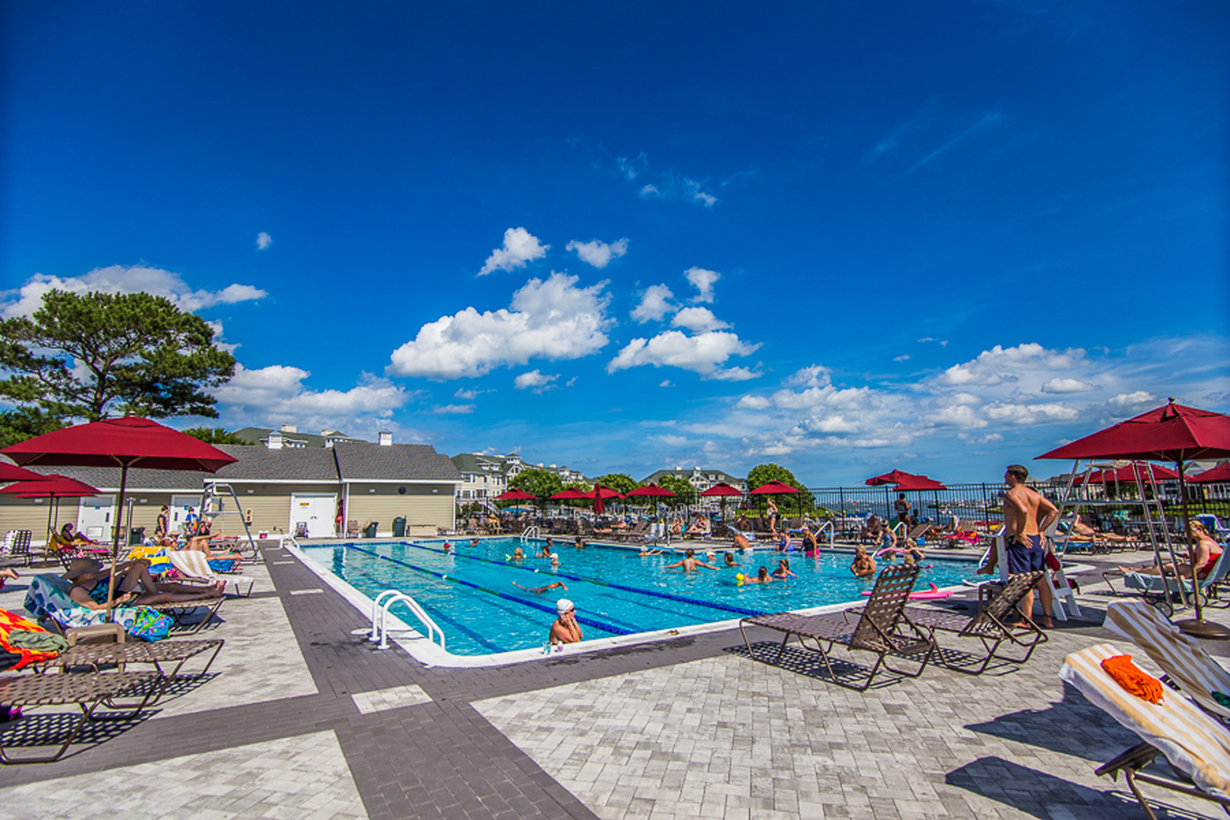 People playing and laying in an outdoor pool.