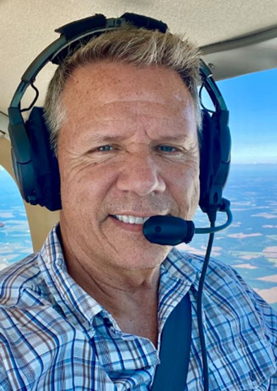 A picture of Phil Schlosser wearing a headset in a plane.